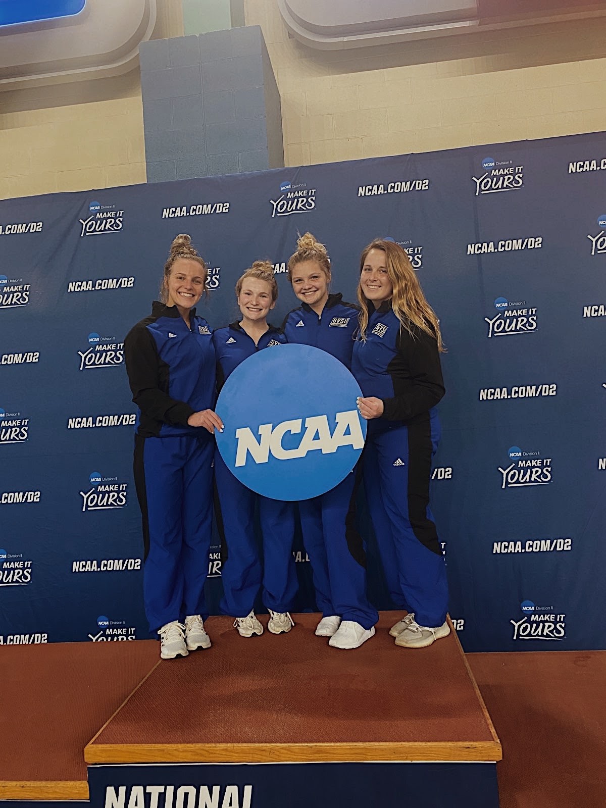 GVSU Women's Diving Team standing by the NCAA logo, posing for a photo